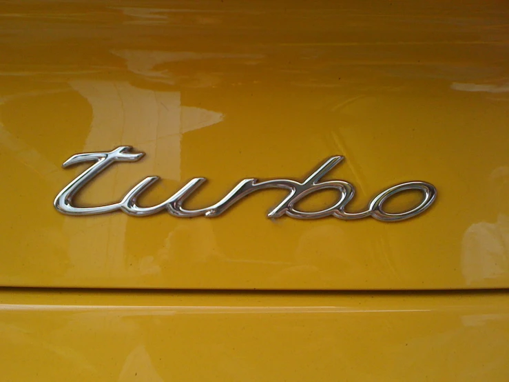 an image of the turbo logo on an antique yellow car