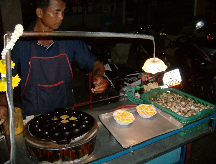 a young man standing next to food and a tray