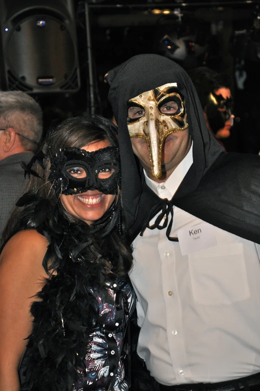 two people in halloween costumes with a guy in a mask on