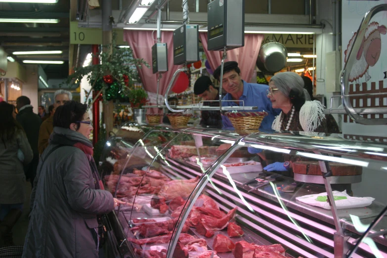 people stand at the store counter with lots of meat