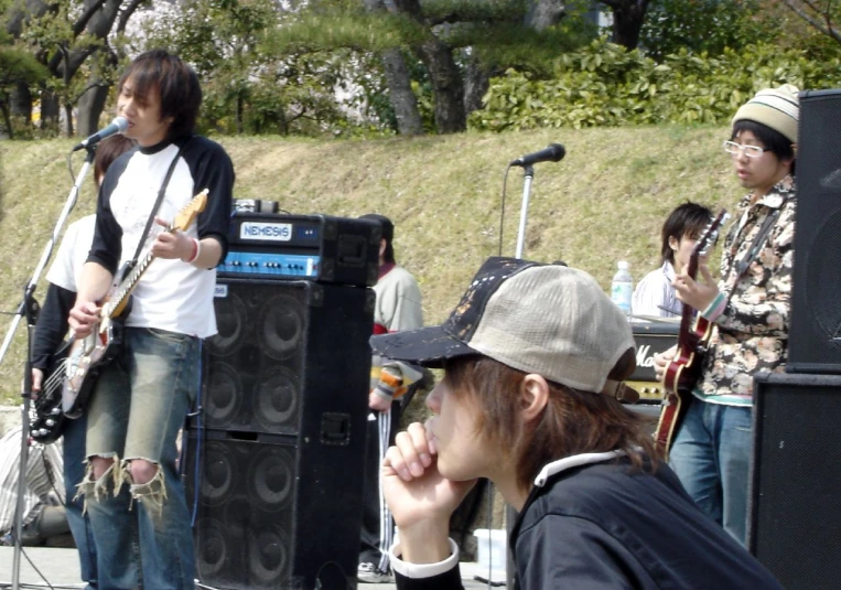 four young men in hats playing instruments at a music festival