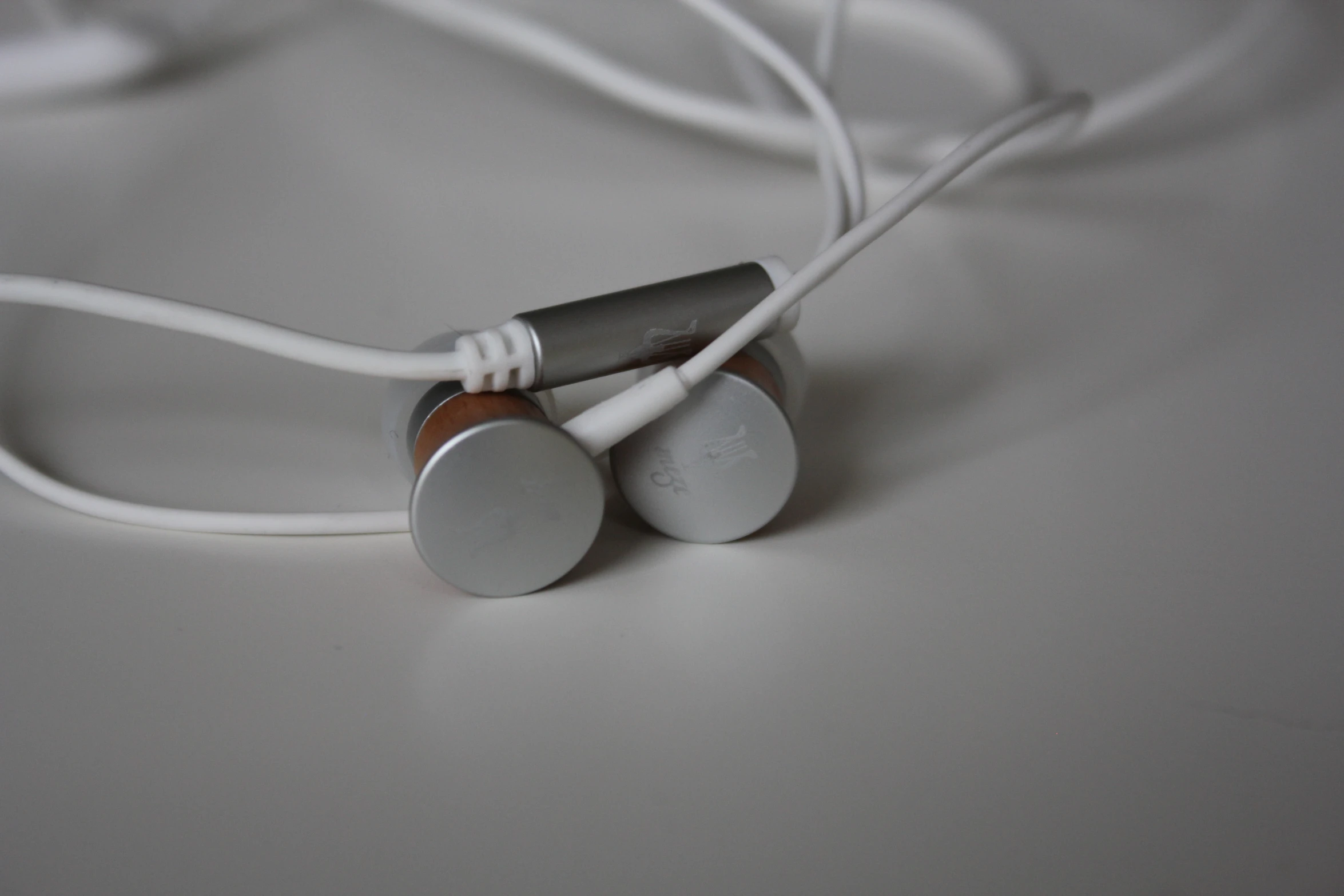 two headphones sitting on a white table next to each other