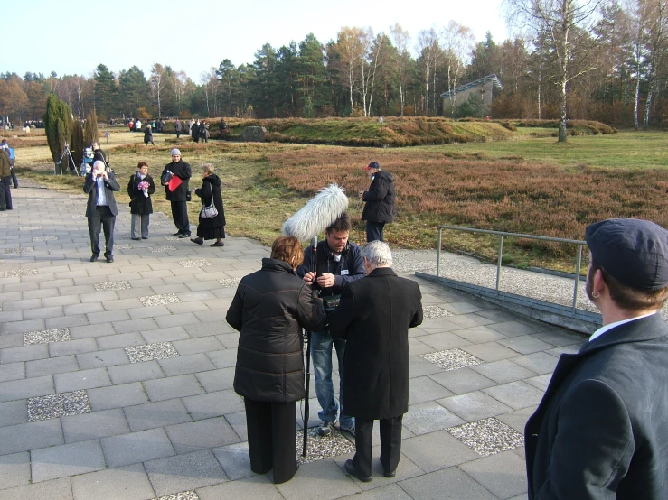 people walking in a park talking and drinking wine