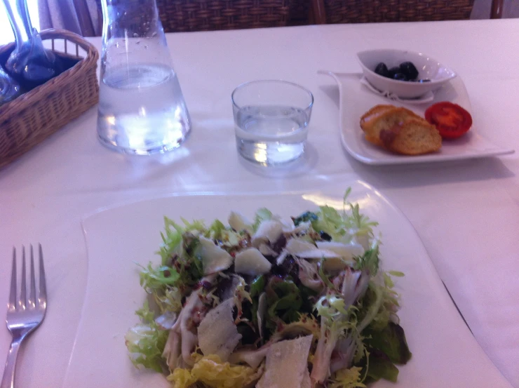 a salad is in the center of a table set for a lunch