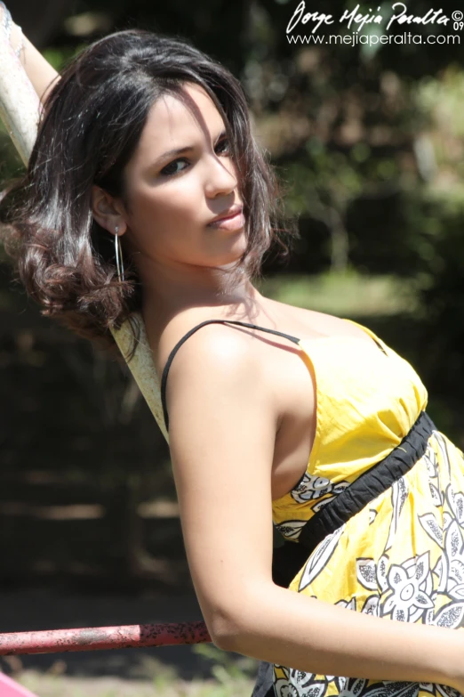 a pretty young lady with short hair wearing a yellow dress