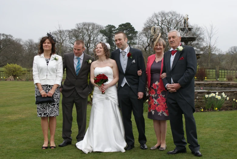 a bride and groom are standing next to other men