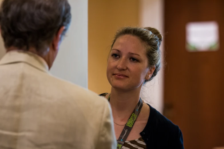 a woman is talking with an older gentleman