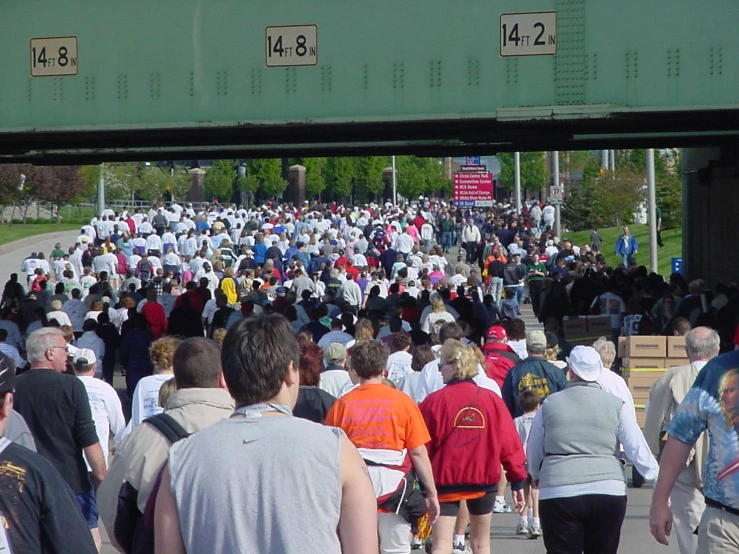 many people are walking along a sidewalk in the city