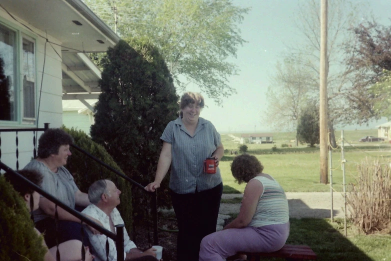 two women and two ladies sitting on a bench at the front porch