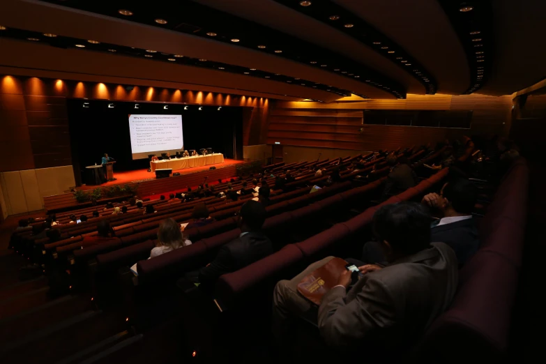 a crowd is watching a presentation on a big screen