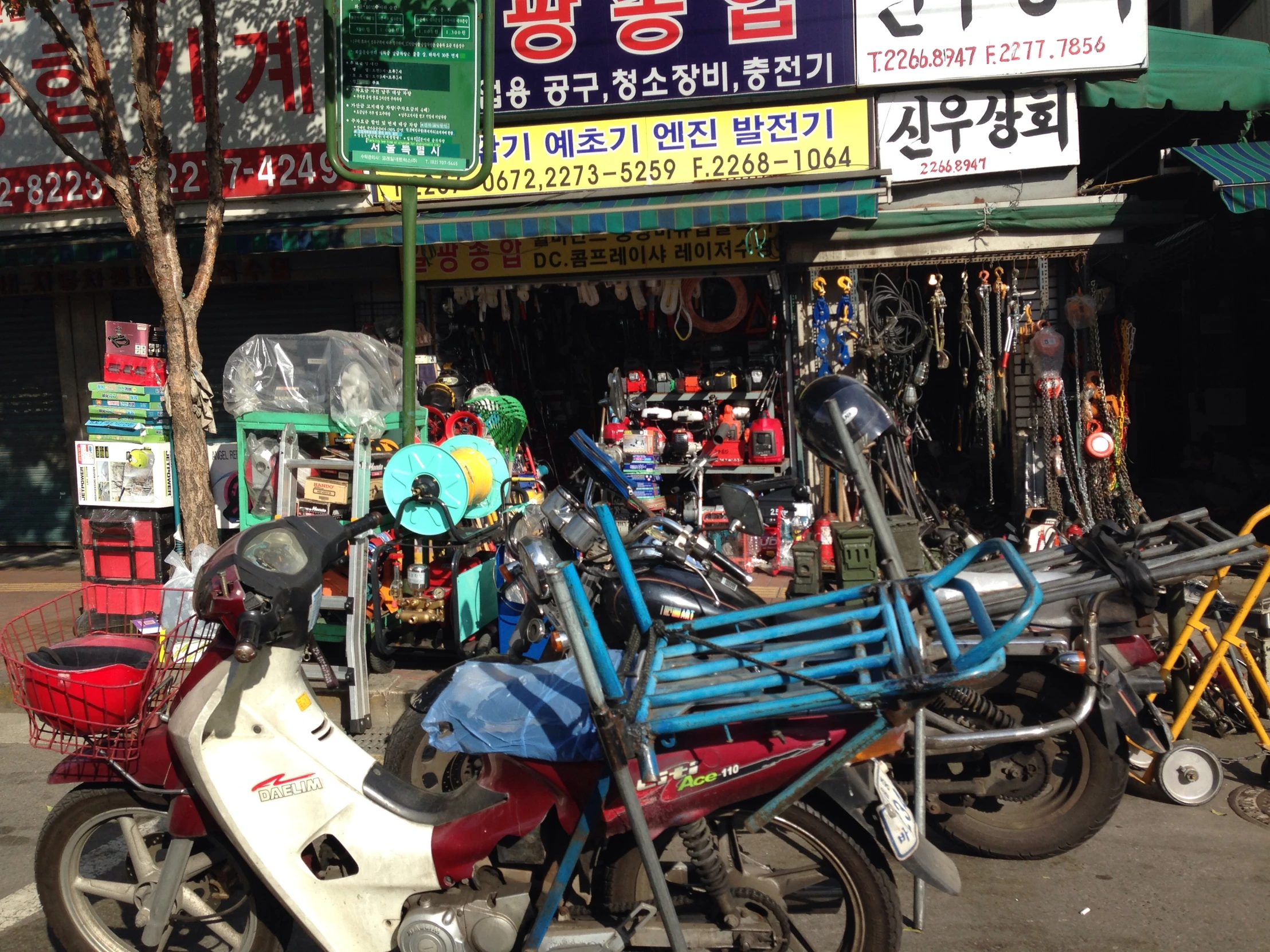 motorcycles parked outside a shop with signs in oriental languages