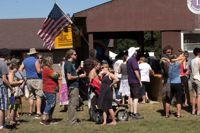 group of people in front of a building with an american flag