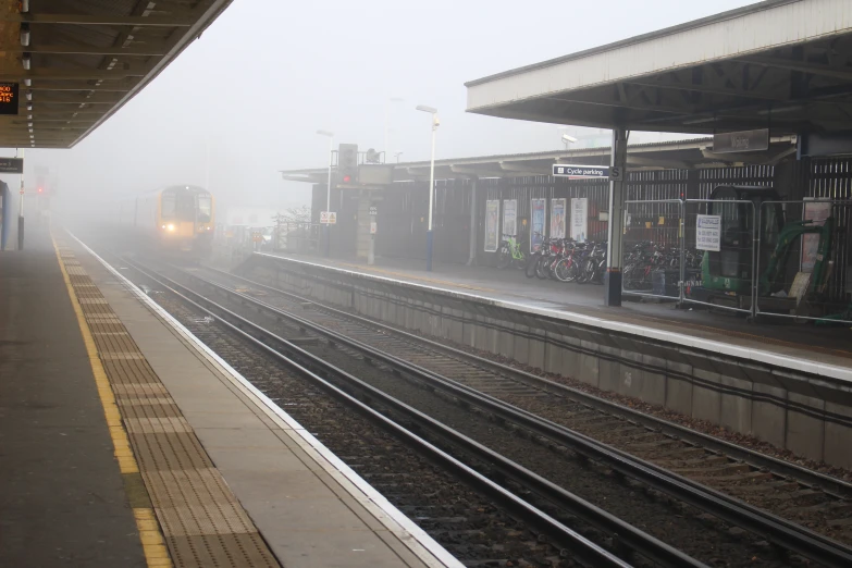 a train is stopped at a foggy station