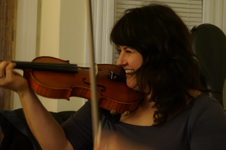 a woman standing and holding a violin in her hands