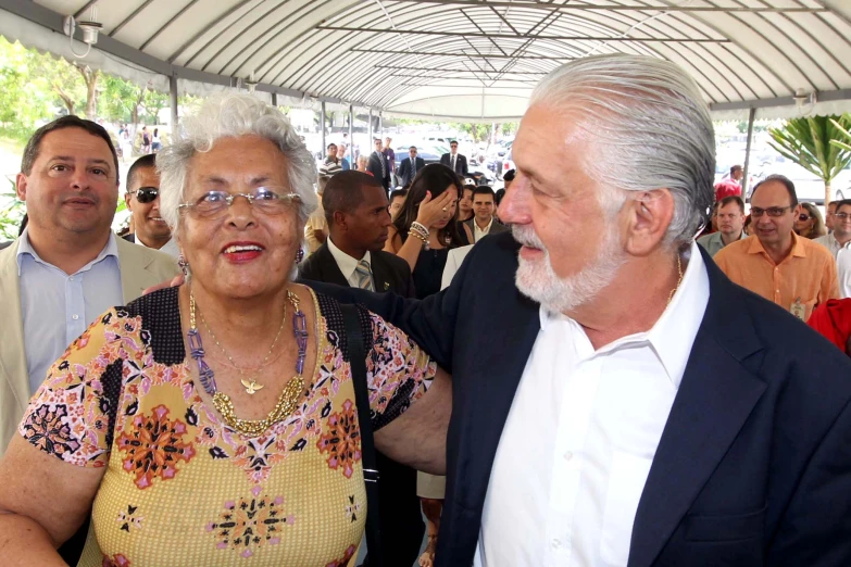 the older man in the black suit stands next to an elderly woman with grey hair