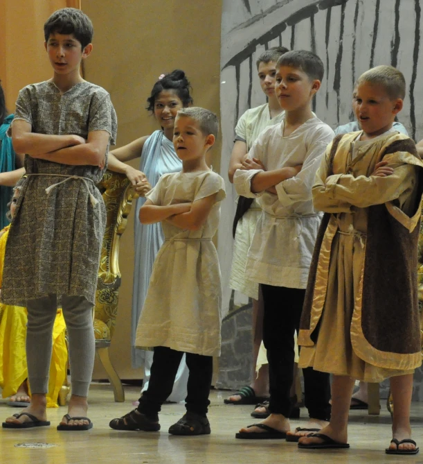 children in costumes watching some dancers