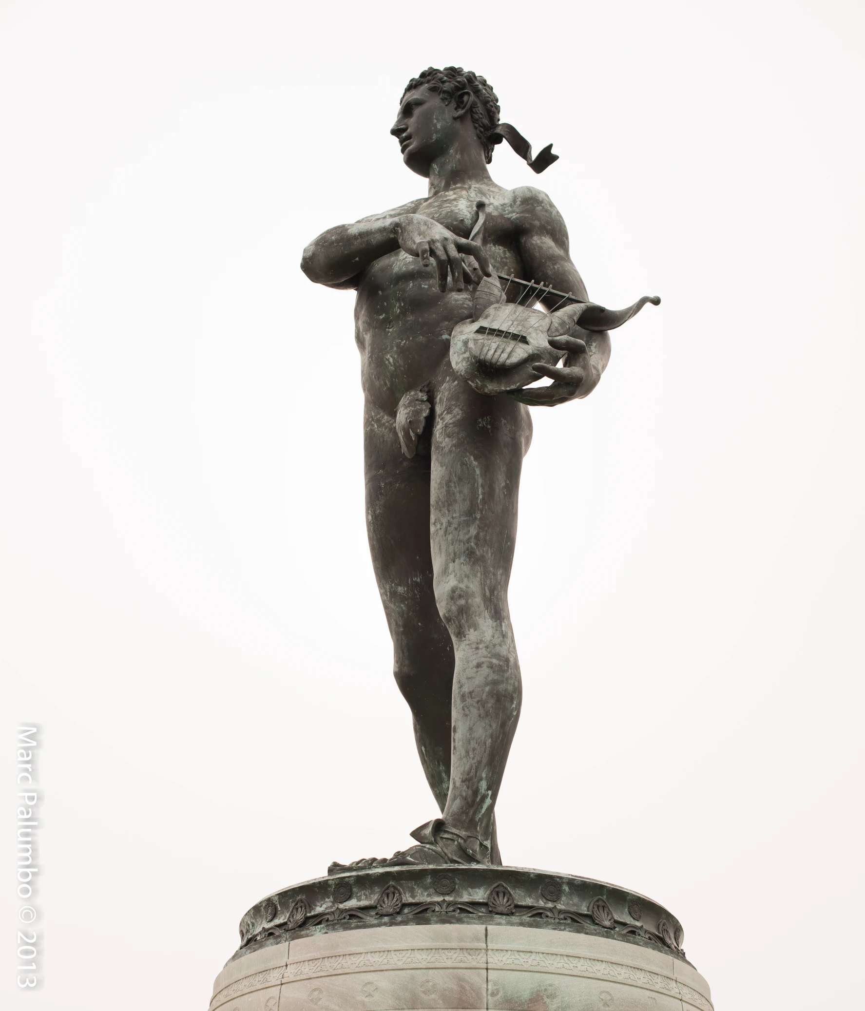 a statue is standing on a pedestal with two birds perched in the air