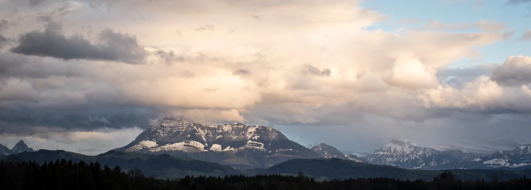 a mountain is shown covered in clouds and snow