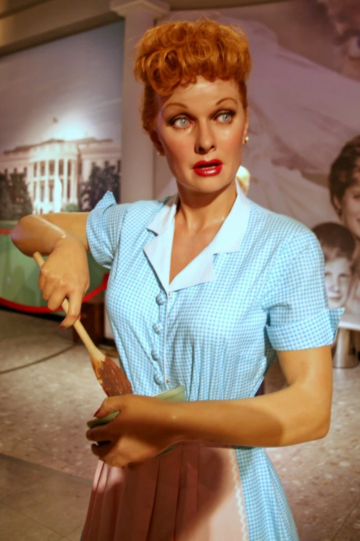 a women with a mustache is wearing a blue shirt and holding a stick