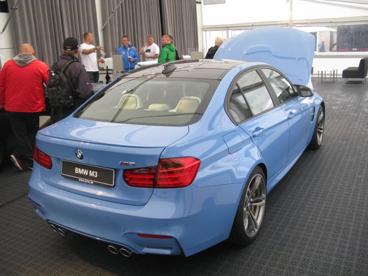a blue bmw car with its trunk open
