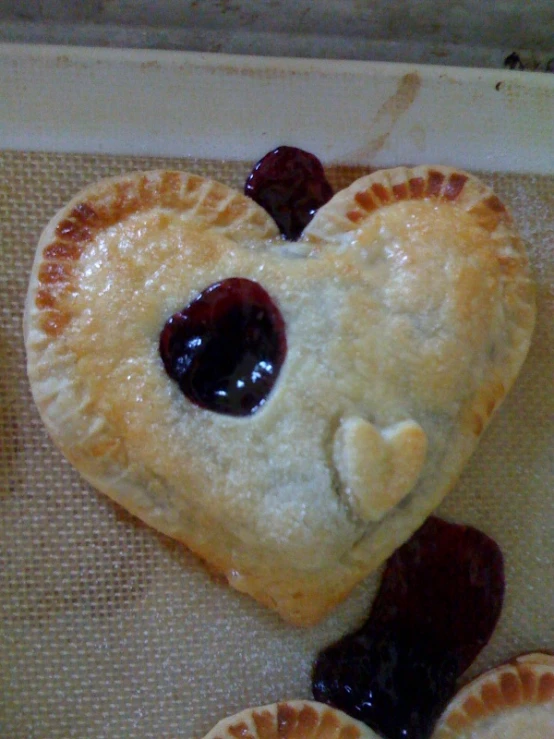 closeup view of heart shaped pastry on baking sheet