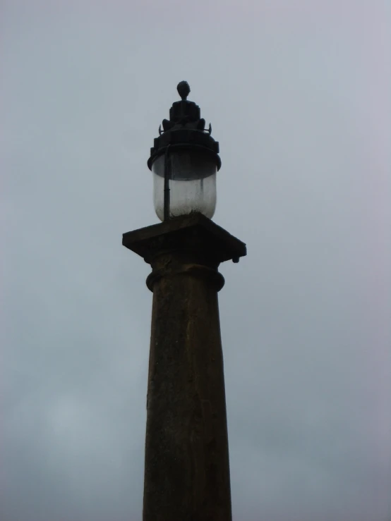 an old light tower in front of a cloudy sky