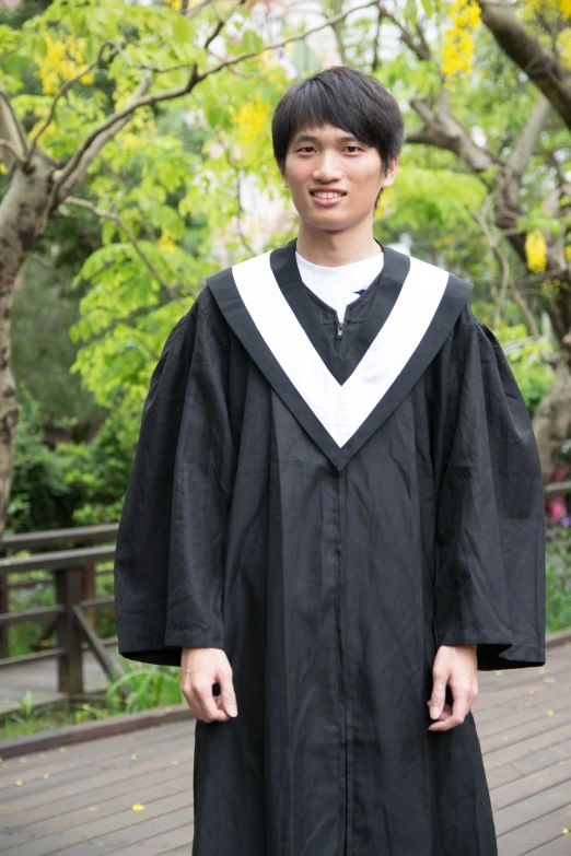 a young man in a black graduation gown