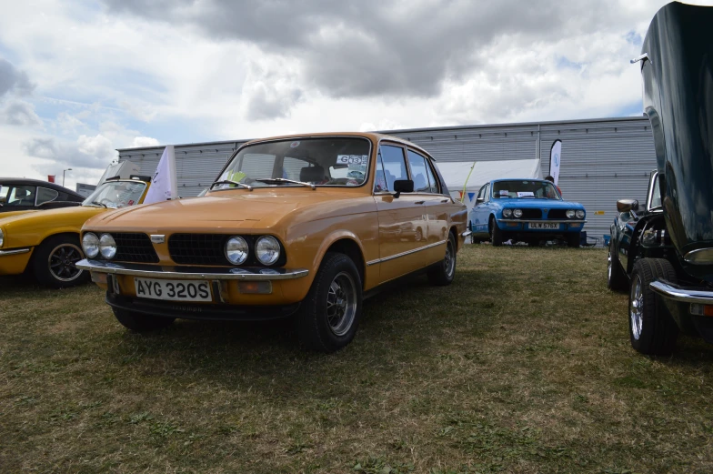 cars are on display outside and one is orange