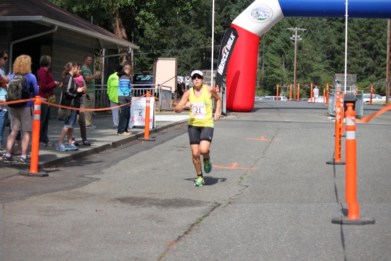 a person in a yellow shirt is running by some orange barriers