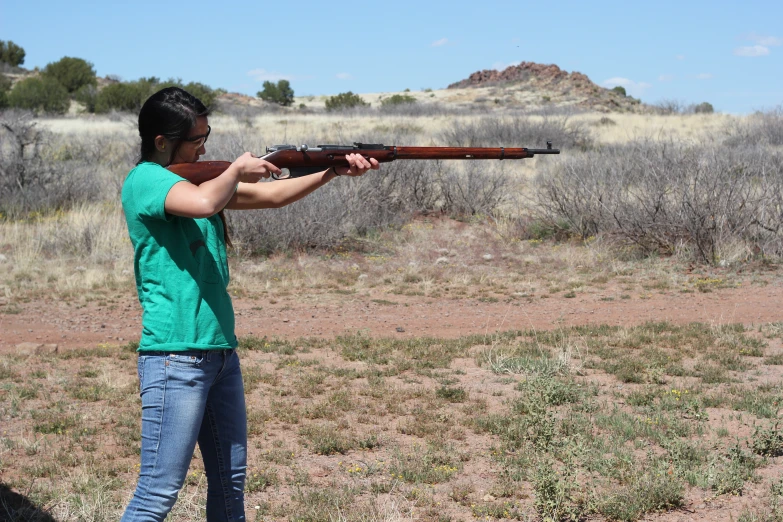 a man is holding a rifle in the field