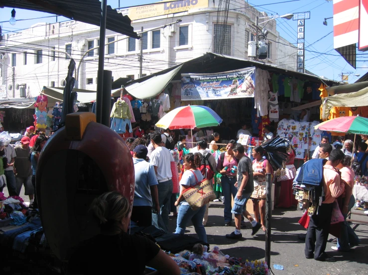 a market with people buying products under umbrellas