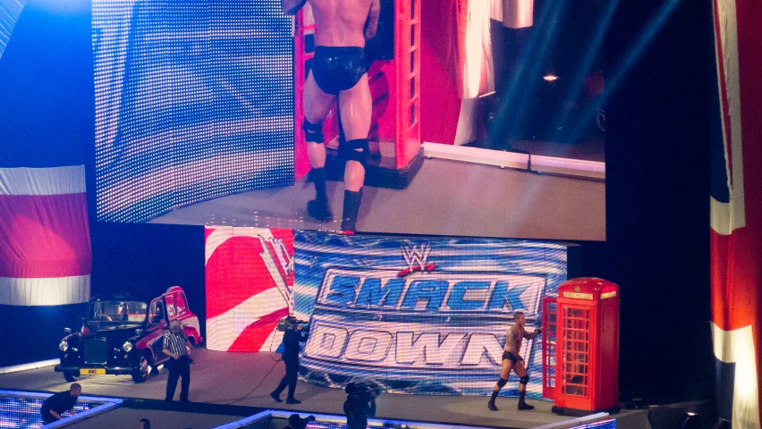 a person standing near a red phone booth and a man in black underwear