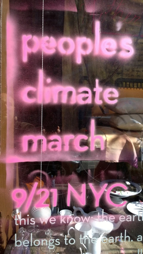 a sign on a window stating people are in the climate march