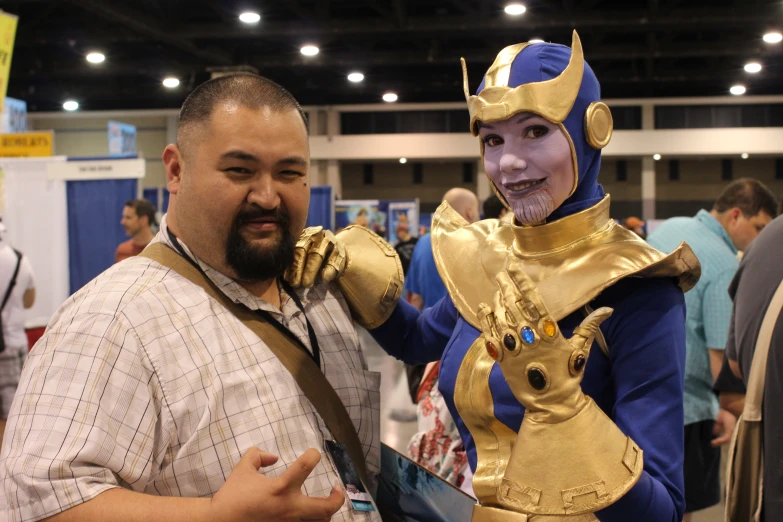 a man standing next to a man wearing a golden costume