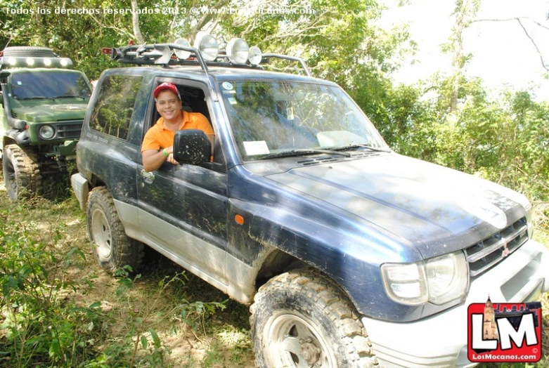 an orange shirted man sitting in the front seat of a suv