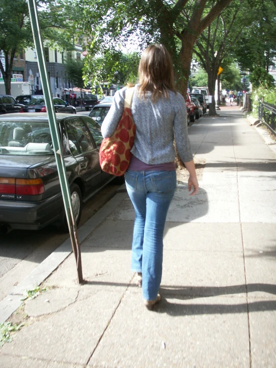 the back view of a woman walking down the street