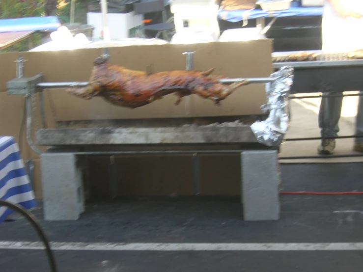 a chicken on a grill on the back of a street