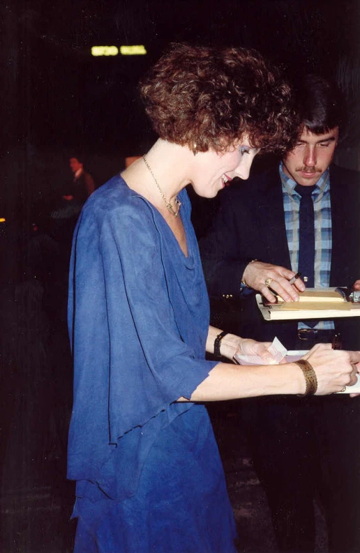 a lady in blue dress holding a box of tissues