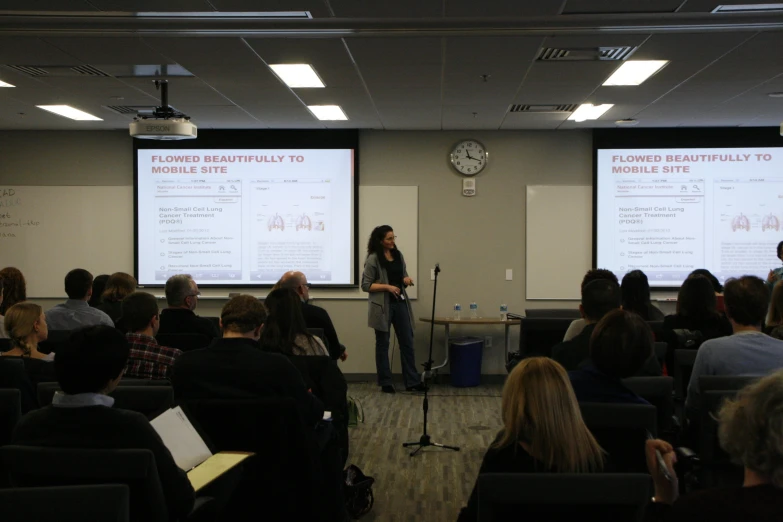 people in a large room with whiteboards on the wall and chairs