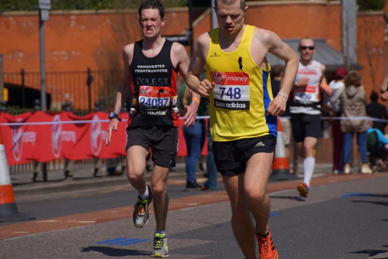 two men run through the streets in matching sports wear