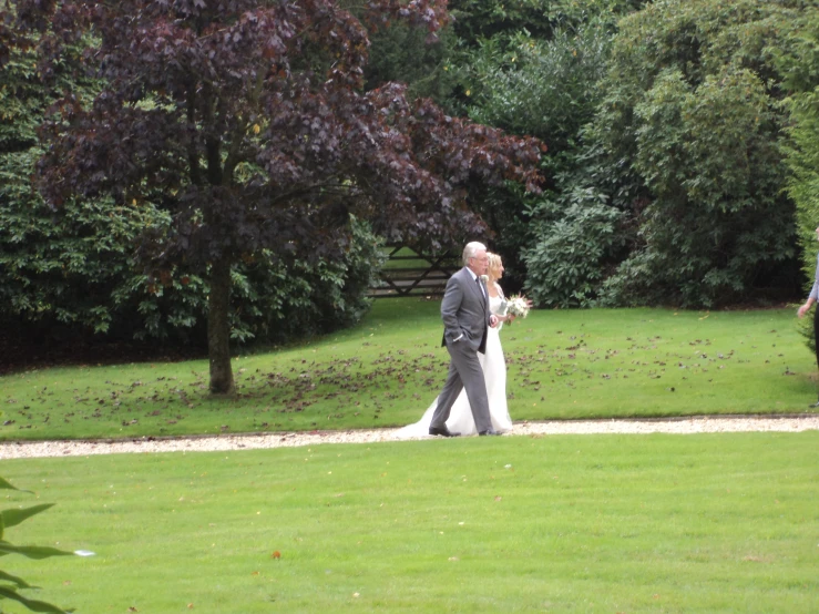 a man and woman are walking through a garden