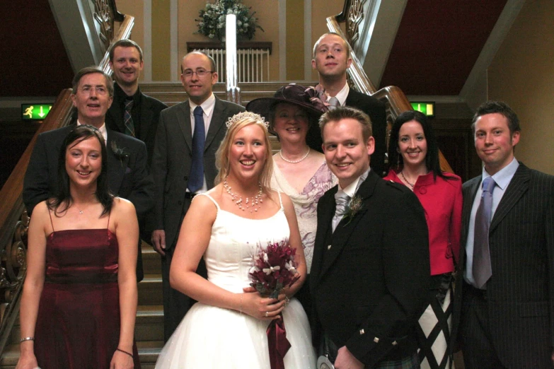 a group of wedding party standing next to each other on stairs