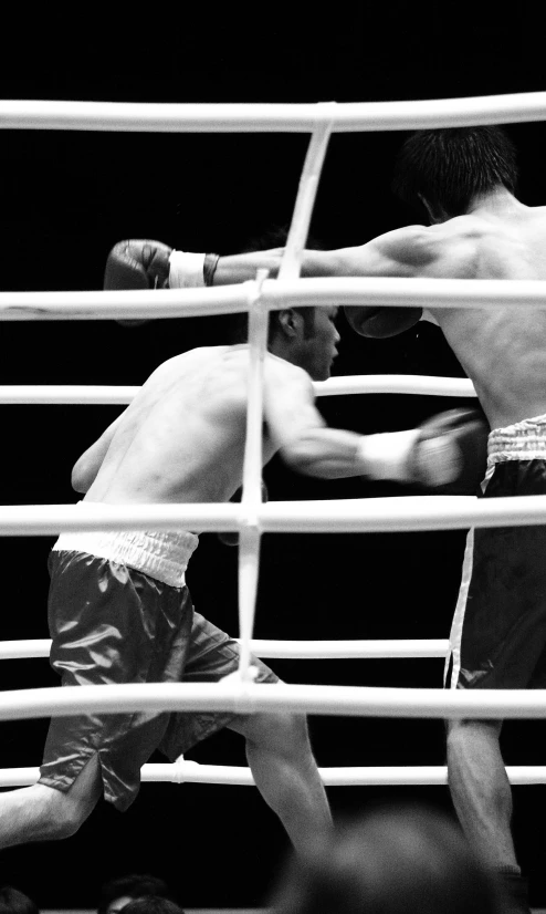 two boxers fight in the middle of a boxing ring