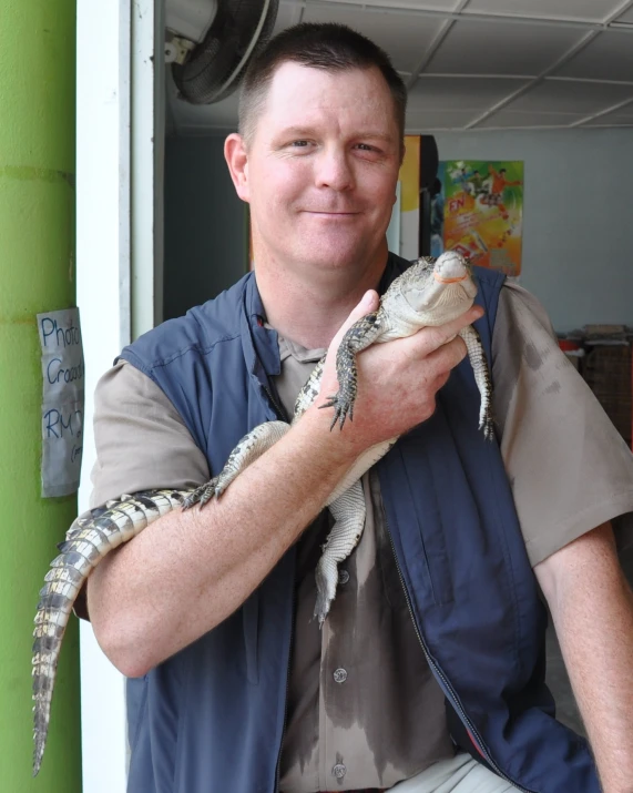 a man is holding two small lizards in his hands