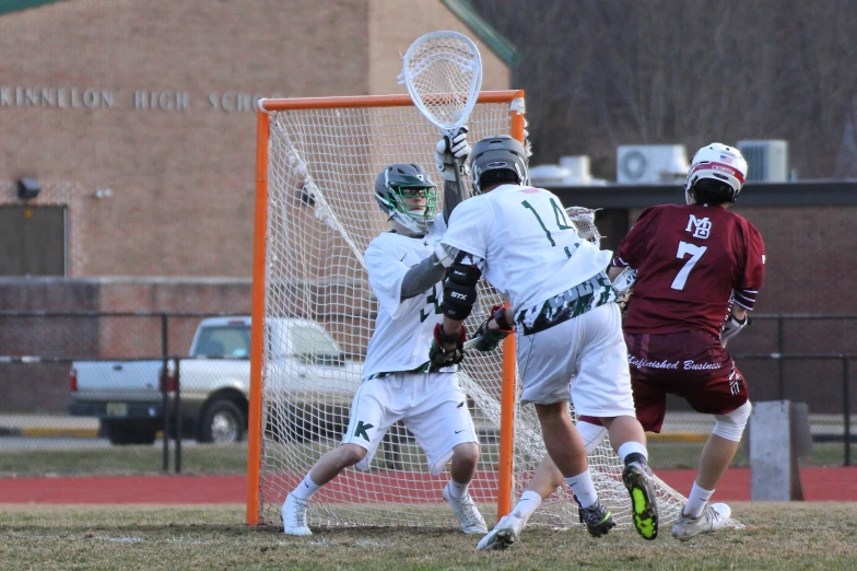 a group of young men playing lacrosse on a field