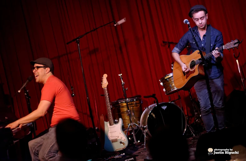 two men with instruments are performing for people