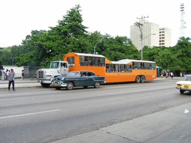 an orange bus in the middle of traffic