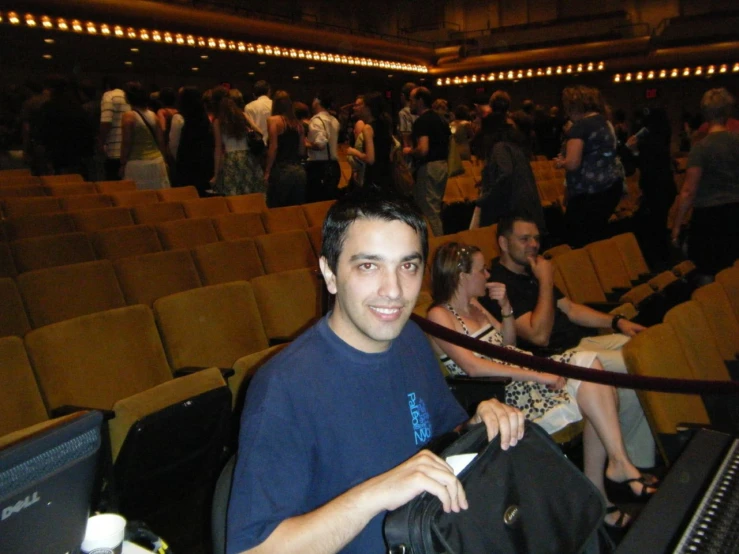 a man sitting at an auditorium waiting for a show