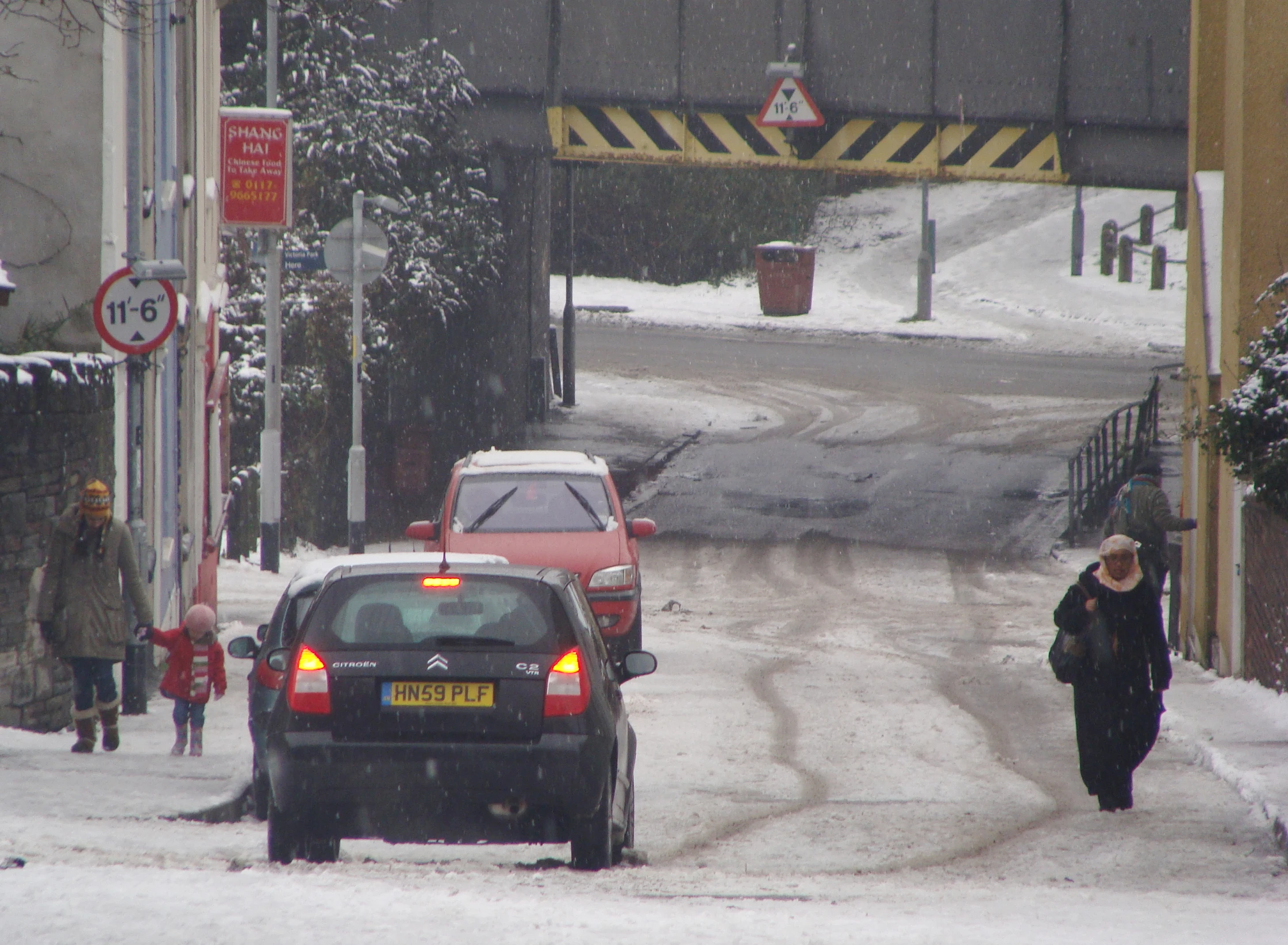 a road with cars, signs and some people on it