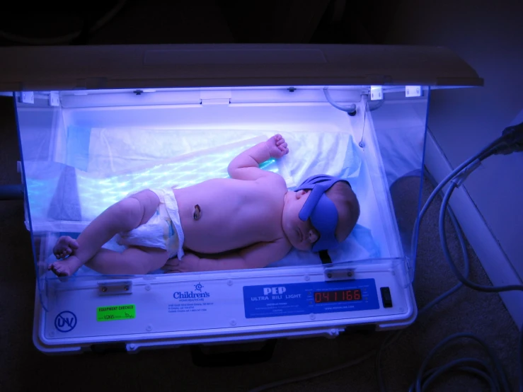 baby lying on top of a scale in the neon light